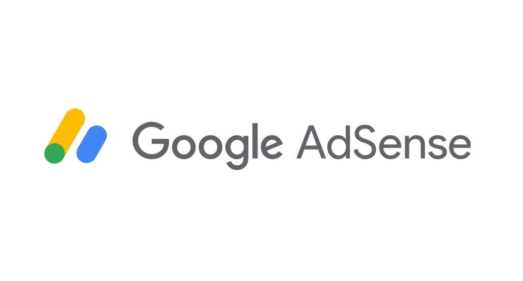 The image displays the Google AdSense logo, which consists of a unique design element and text. On the left, there are two overlapping oblong shapes, one yellow and one blue, creating a shadow effect. To the right, the word "Google" is written in a sleek grey font, with the "AdSense" part in a similar but slightly lighter grey, emphasizing the service name. The text is in a modern sans-serif font, and the entire logo is set against a plain white background, conveying a simple yet distinct brand identity associated with Google's advertising service.