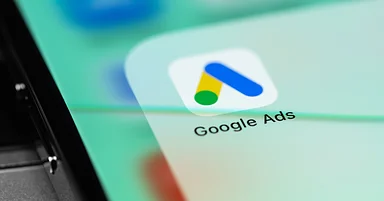 A close-up view of a mobile device displaying the colorful Google Ads app icon on its screen, with the app name ‘Google Ads’ clearly visible below the icon.