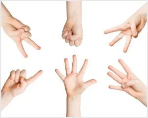 Seven hands of diverse sizes arranged in a circle against a white background, each displaying different gestures including pointing, an open palm, and various finger positions