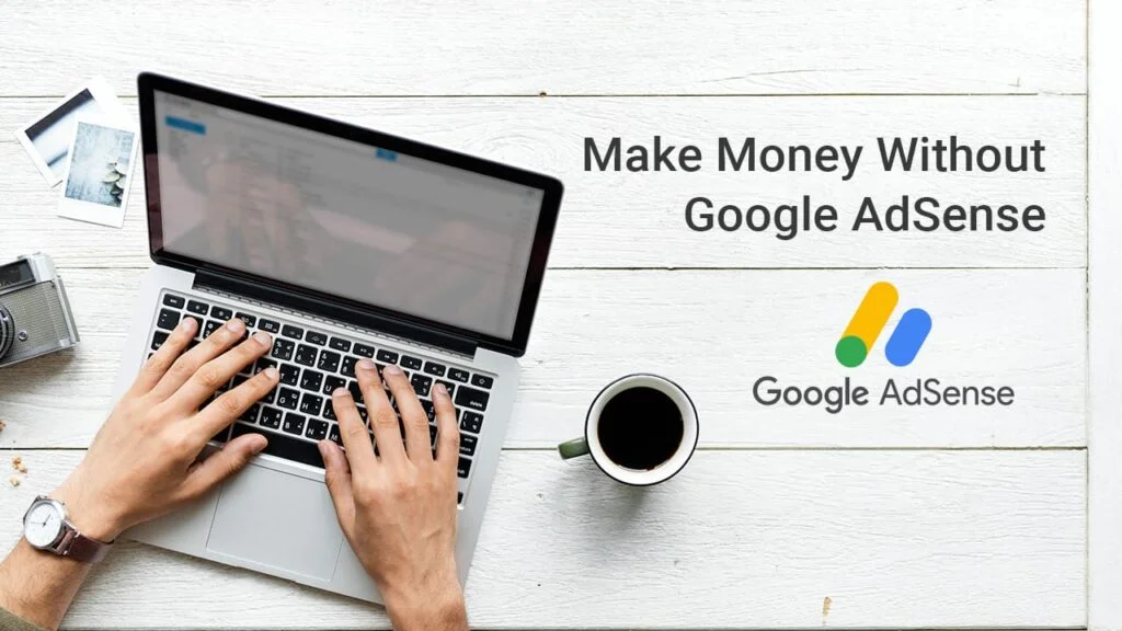 Overhead view of a person using a laptop placed on a white wooden table, with the phrase 'Make Money Without Google AdSense' next to the Google AdSense logo, suggesting alternative monetization strategies for bloggers. Accompanying the setup is a cup of coffee and a camera, depicting a casual work environment